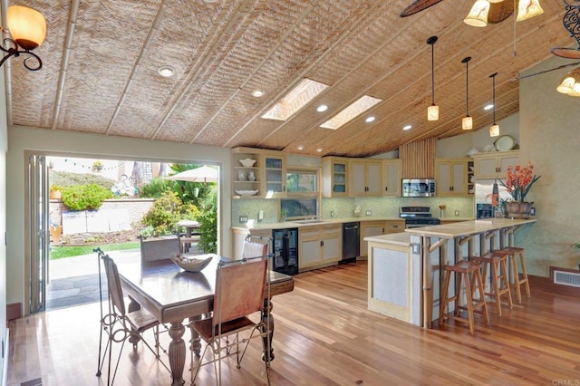 dining room featuring high vaulted ceiling, beverage cooler, and light hardwood / wood-style floors