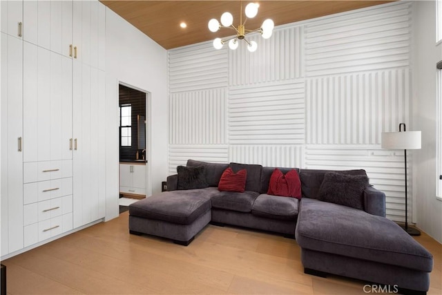 living room with light wood-type flooring, an inviting chandelier, and wood ceiling