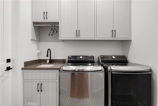 laundry room with cabinets, separate washer and dryer, and sink