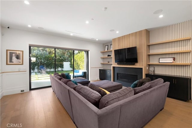 living room with a large fireplace and light hardwood / wood-style flooring