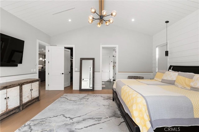 bedroom featuring hardwood / wood-style flooring, a chandelier, and high vaulted ceiling