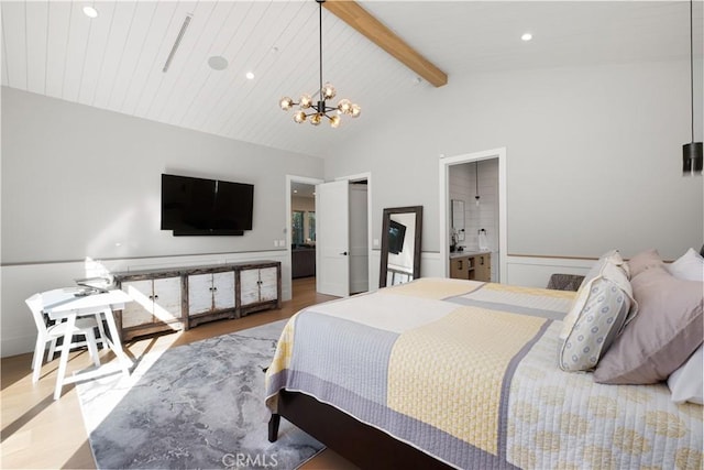 bedroom featuring ensuite bath, hardwood / wood-style floors, beam ceiling, high vaulted ceiling, and a chandelier