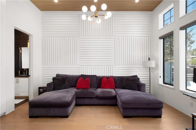 living room with an inviting chandelier, wood ceiling, and light hardwood / wood-style floors