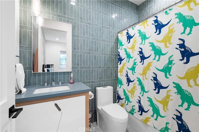 bathroom with vanity, toilet, tile walls, and backsplash