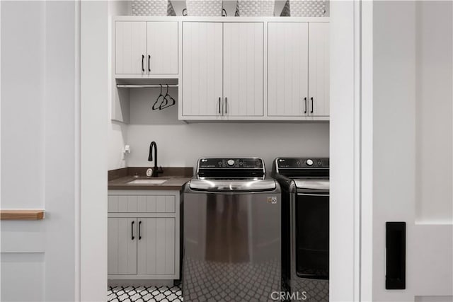 washroom featuring cabinets, sink, and washing machine and dryer