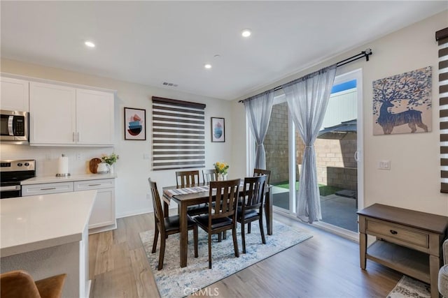 dining space with light hardwood / wood-style flooring