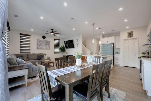 dining area with light hardwood / wood-style flooring and ceiling fan