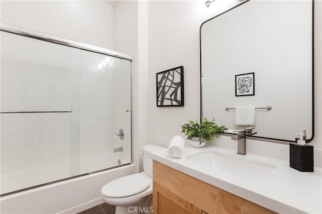 full bathroom featuring vanity, toilet, and shower / bath combination with glass door