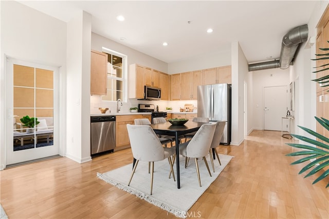 dining space with light hardwood / wood-style floors and sink