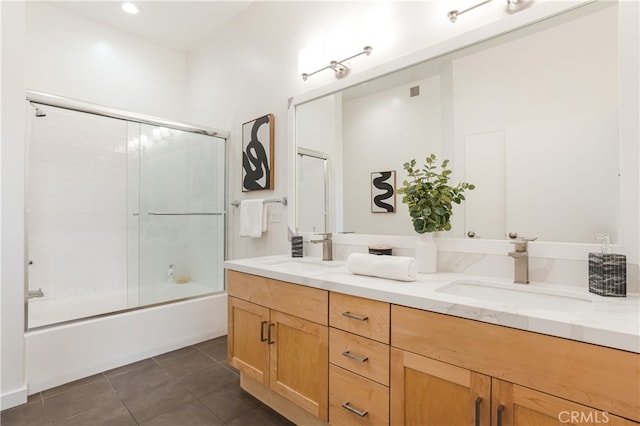 bathroom featuring tile patterned floors, enclosed tub / shower combo, and vanity