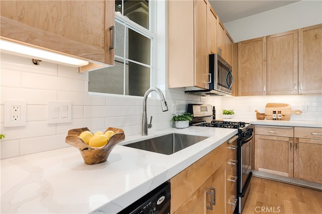 kitchen featuring sink, light hardwood / wood-style flooring, appliances with stainless steel finishes, and decorative backsplash