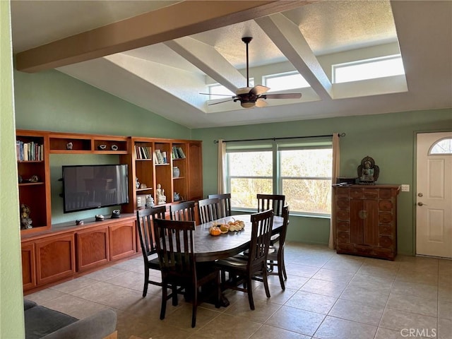 dining area with a textured ceiling, ceiling fan, light tile patterned flooring, and vaulted ceiling with beams