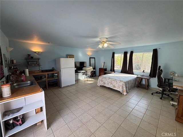 bedroom with ceiling fan, light tile patterned floors, sink, and white fridge