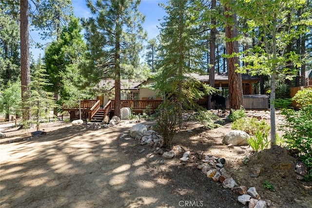 view of front facade with a wooden deck and a hot tub