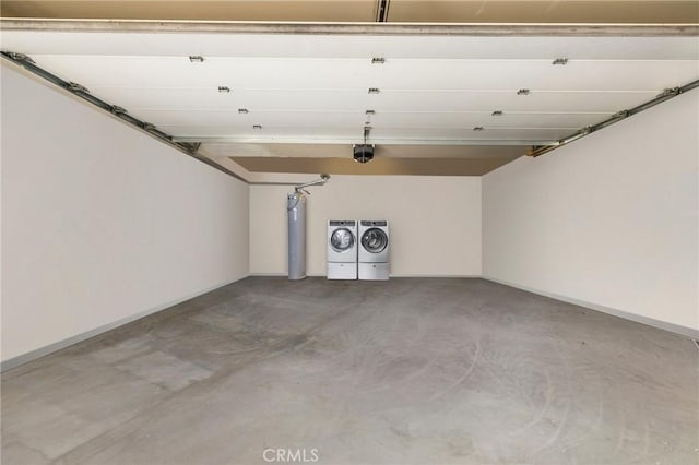 garage featuring a garage door opener, water heater, and washing machine and clothes dryer