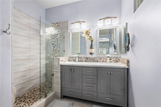 bathroom with vanity and a tile shower