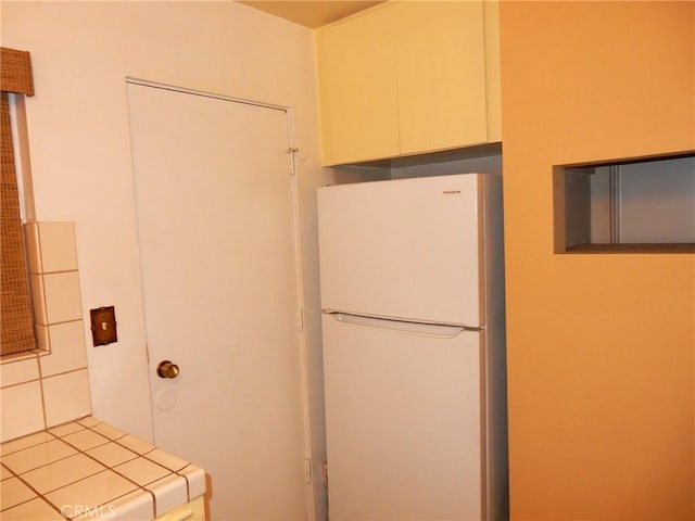 kitchen with tile countertops and white fridge