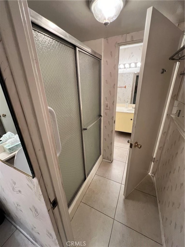 bathroom with tile patterned flooring, vanity, and walk in shower