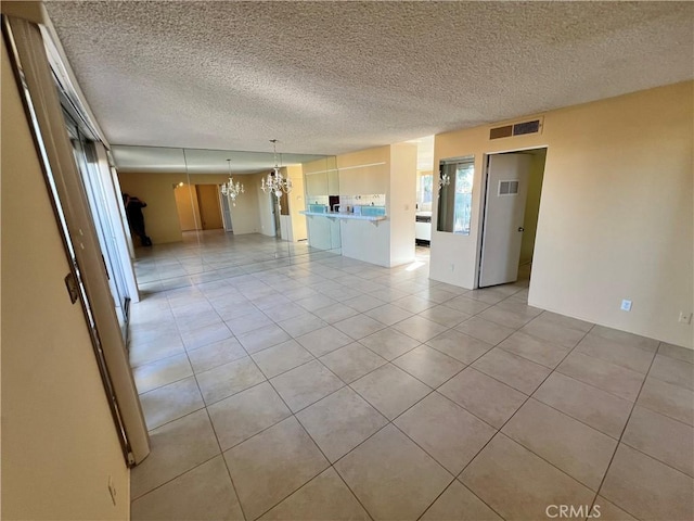 42278 Dunes View Rd Unit 28, Rancho Mirage, CA 92270 - empty room with light tile patterned floors, a textured ceiling, and a chandelier