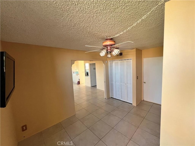 hallway featuring light tile patterned flooring and a textured ceiling