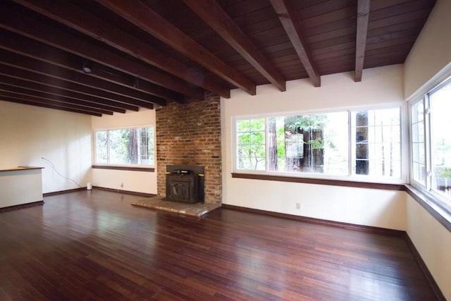 unfurnished living room with beam ceiling, plenty of natural light, and dark hardwood / wood-style floors