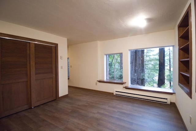 unfurnished bedroom with a closet, dark hardwood / wood-style floors, and a baseboard radiator