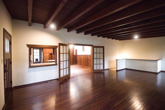 spare room with dark wood-type flooring, beam ceiling, and french doors