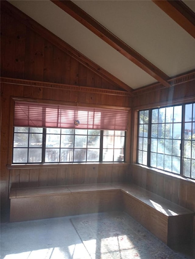 empty room featuring lofted ceiling with beams