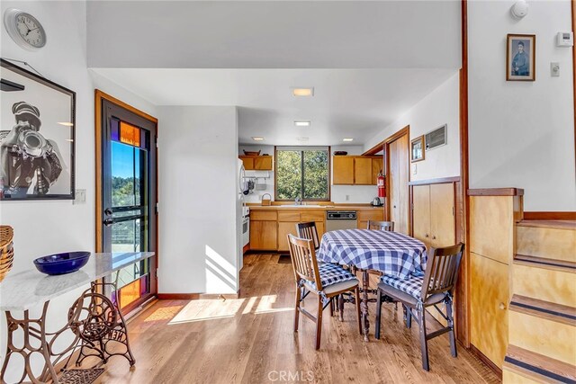 dining room featuring sink and light hardwood / wood-style floors