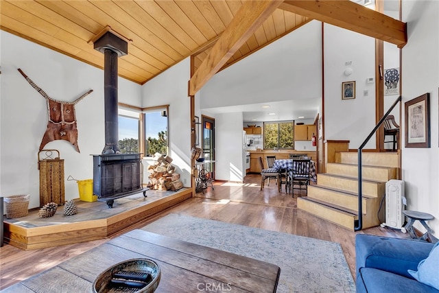 living room featuring wood ceiling, plenty of natural light, a wood stove, and hardwood / wood-style floors