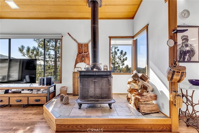 living room with a wood stove and wood ceiling