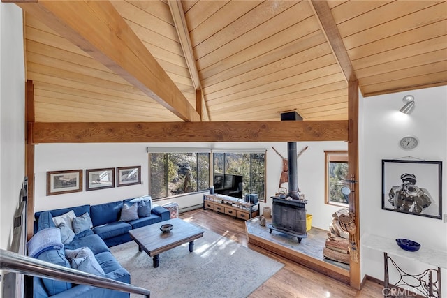 living room with wooden ceiling, a wood stove, hardwood / wood-style flooring, and beam ceiling