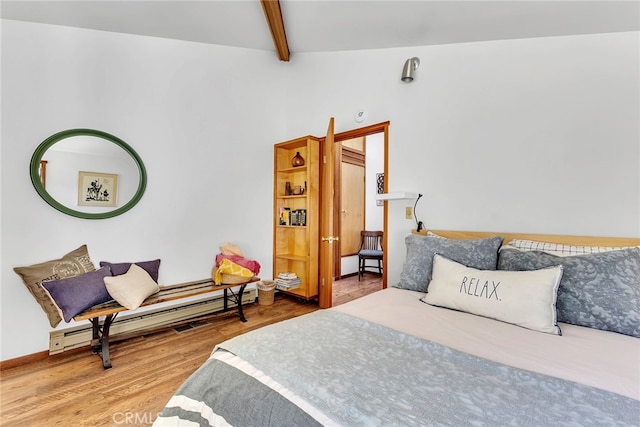 bedroom featuring hardwood / wood-style flooring, baseboard heating, and beam ceiling