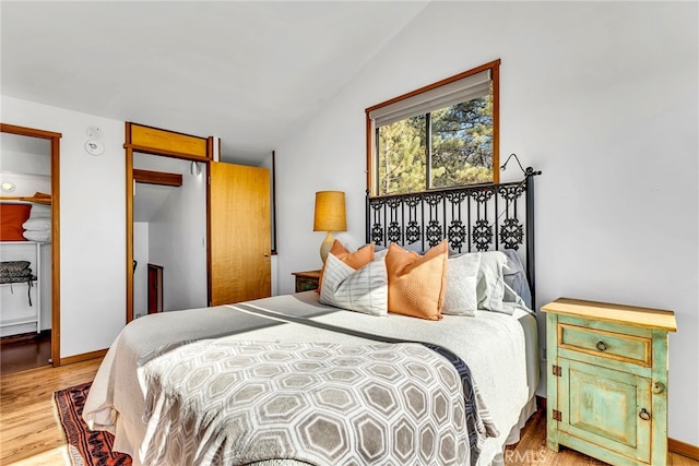 bedroom featuring lofted ceiling and hardwood / wood-style flooring