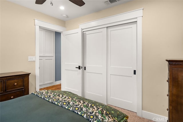 carpeted bedroom with ceiling fan and a closet