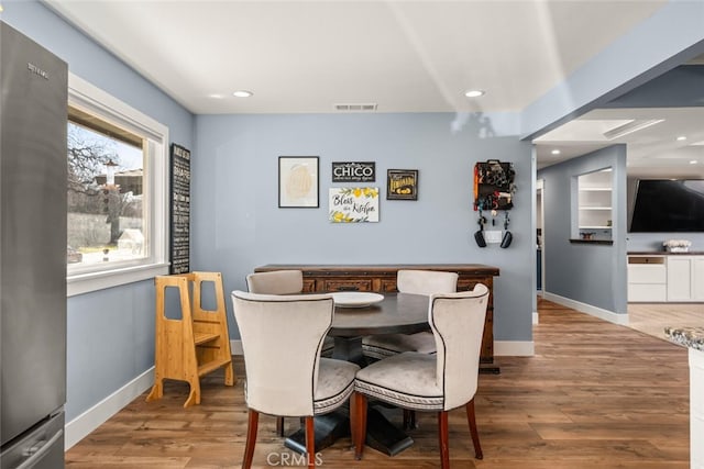 dining space with hardwood / wood-style flooring