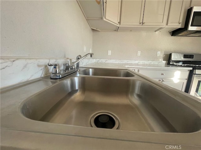 room details featuring appliances with stainless steel finishes and sink