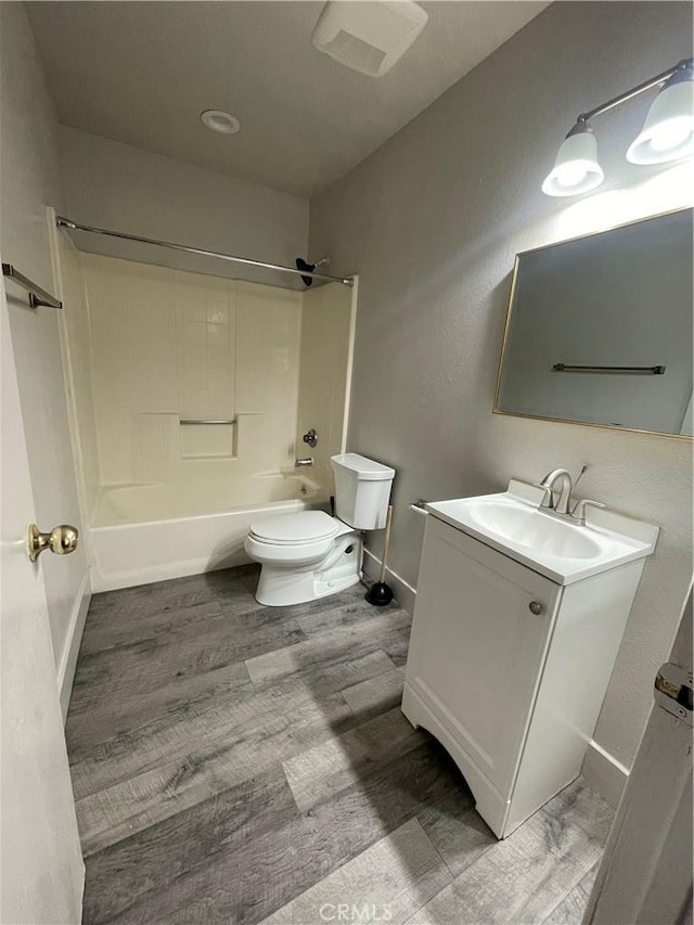 full bathroom with shower / bathing tub combination, vanity, wood-type flooring, and toilet