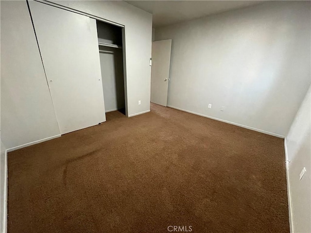 unfurnished bedroom with a closet and carpet flooring