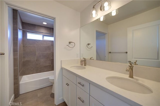 full bathroom featuring tile patterned floors, vanity, toilet, and tiled shower / bath combo