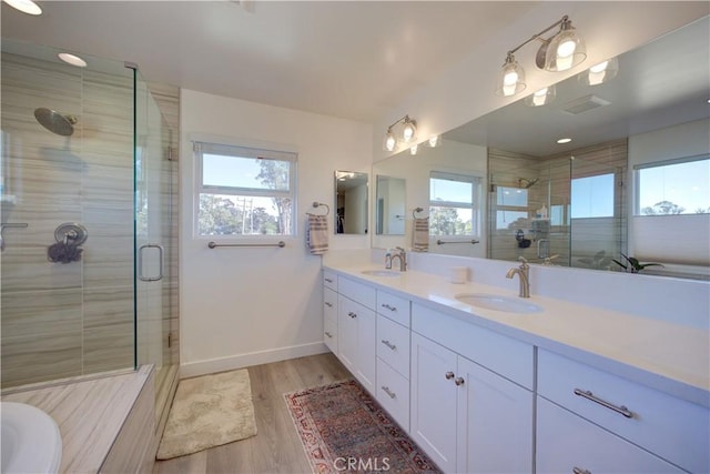 bathroom with vanity, hardwood / wood-style floors, and a shower with shower door