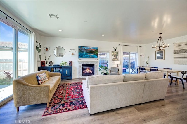 2510 Terrace Sands Ln, Oceano, CA 93445 - living area with a chandelier, visible vents, a warm lit fireplace, recessed lighting, and wood finished floors