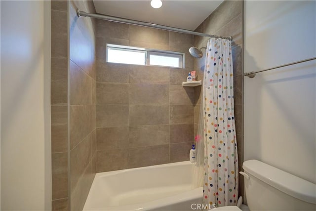 bathroom featuring shower / tub combo and toilet