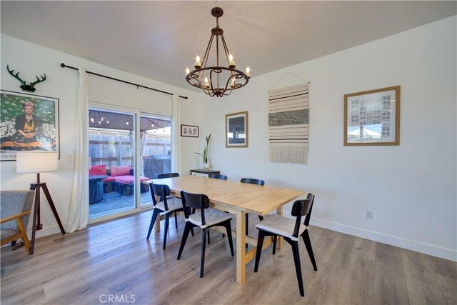 dining area featuring light hardwood / wood-style floors and a chandelier