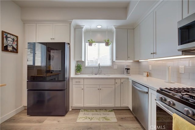 2510 Terrace Sands Ln, Oceano, CA 93445 - kitchen featuring a sink, stainless steel appliances, backsplash, light countertops, and white cabinets