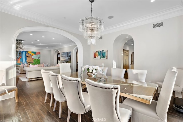 dining area with dark wood-style floors, arched walkways, and visible vents