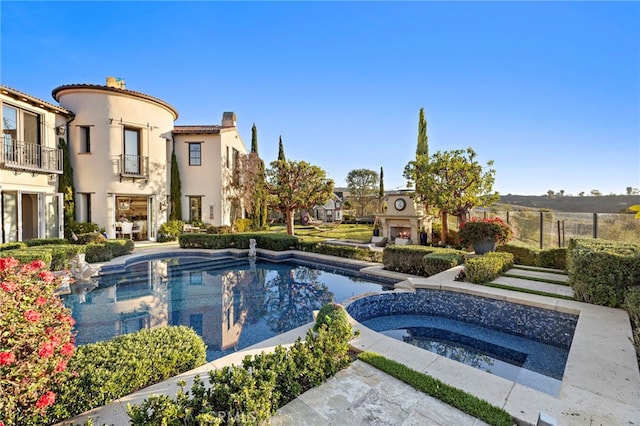 view of pool with a pool with connected hot tub