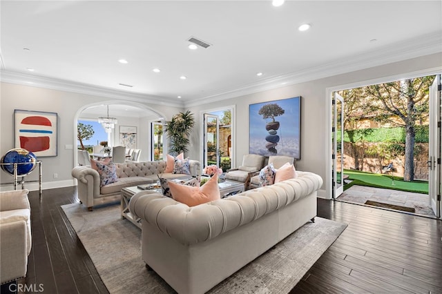 living area with a healthy amount of sunlight, hardwood / wood-style flooring, visible vents, and arched walkways