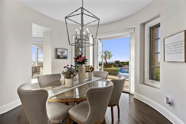 dining room with an inviting chandelier, plenty of natural light, baseboards, and dark wood-style flooring