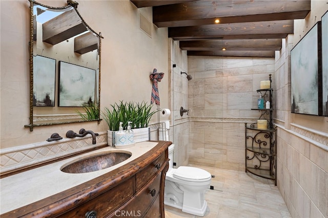 full bathroom featuring beam ceiling, tiled shower, vanity, and toilet